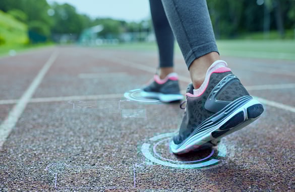 Person walking away from camera with insole pressure sensors in their shoes.