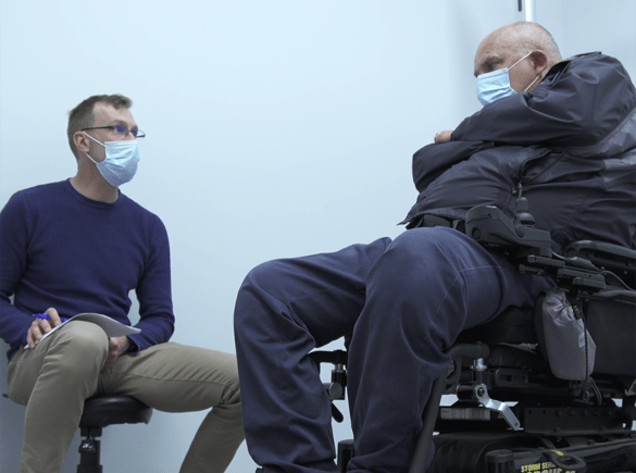 Occupational Therapist Timothy Hill discusses strategy with his wheelchair-bound patient.