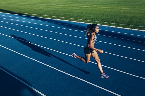 Woman running on an outdoor track.