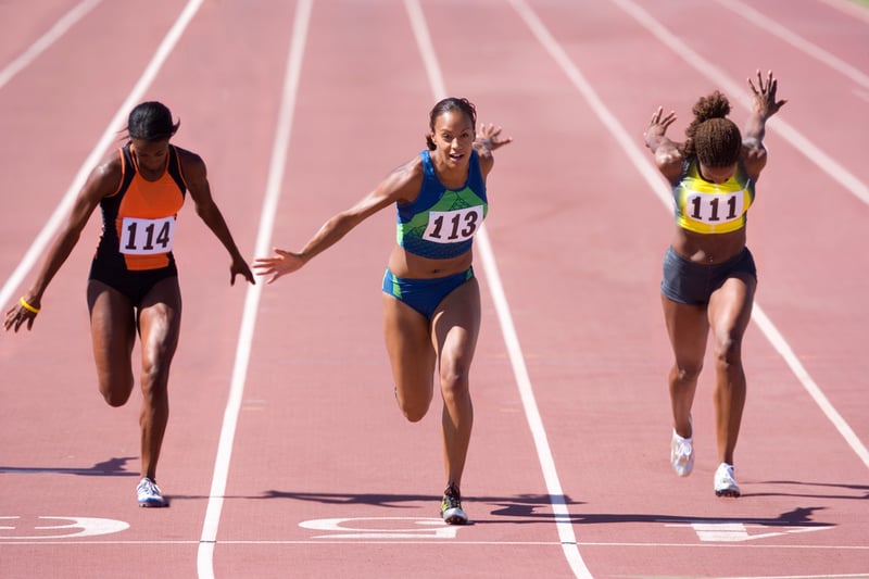 Athletes sprinting on a running track.